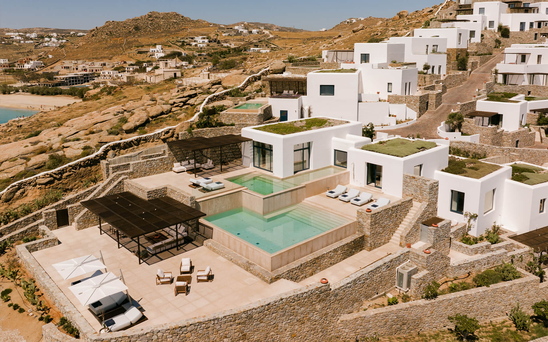 Villa Calliope exterior: Stunning luxury villa with two swimming pools and private terraces, set in a serene Mykonos landscape.