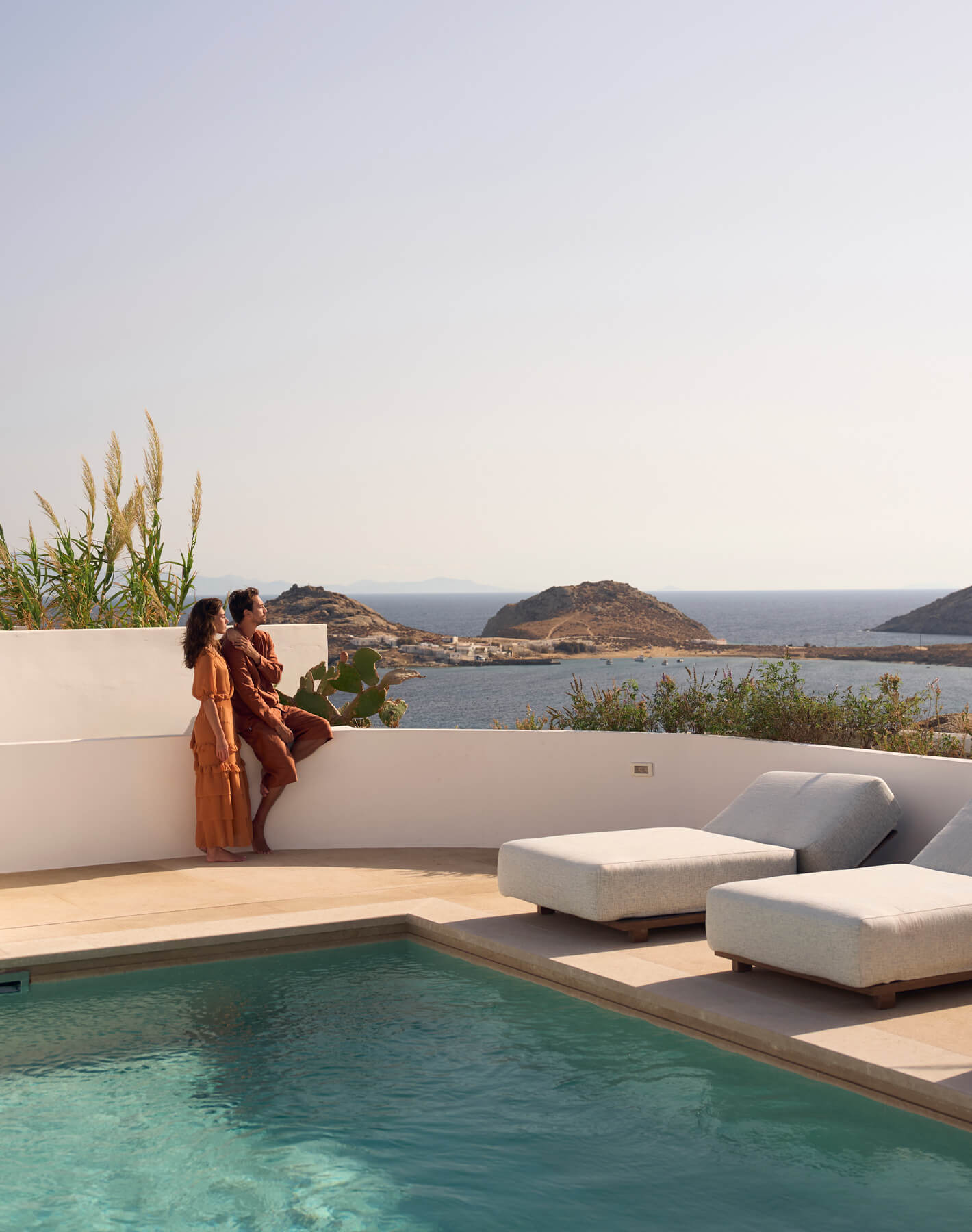 Couple unwinding on their terrace with a pool, soaking in the Mykonos sunset at Cali Resort