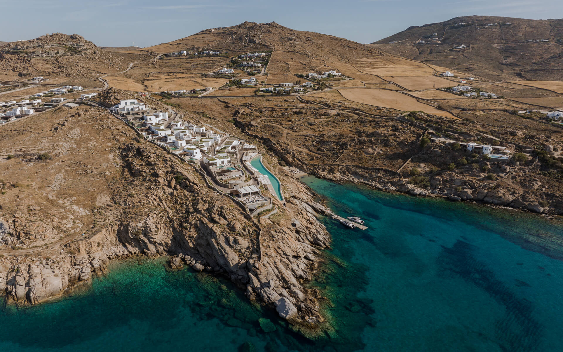 drone view of Cali resort, nestled on the south edge of Mykonos and surrounded by the crystal blue Aegean Sea under the radiant sun