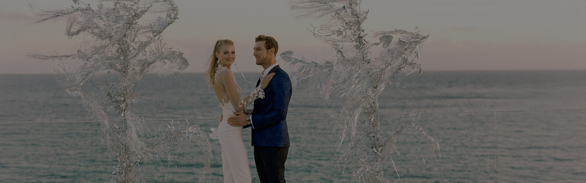 A romantic wedding ceremony at Cali Mykonos overlooking the sparkling Aegean Sea. The bride and groom exchange vows in a breathtaking coastal setting, surrounded by luxury, elegance, and Mediterranean charm. Cali Mykonos wedding venue offers stunning views, luxury accommodations, and personalized service, creating unforgettable moments for couples celebrating their special day.
