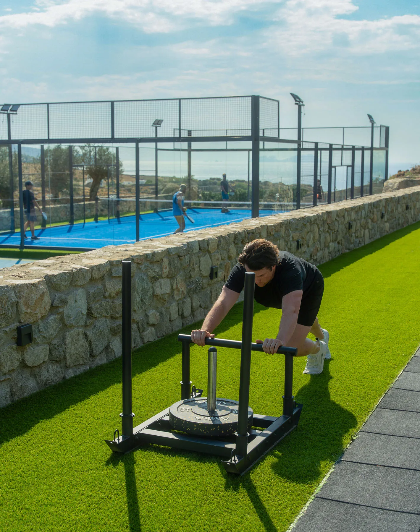 Outdoor sled training at Terra Wellness Club beside the padel courts at Cali Mykonos