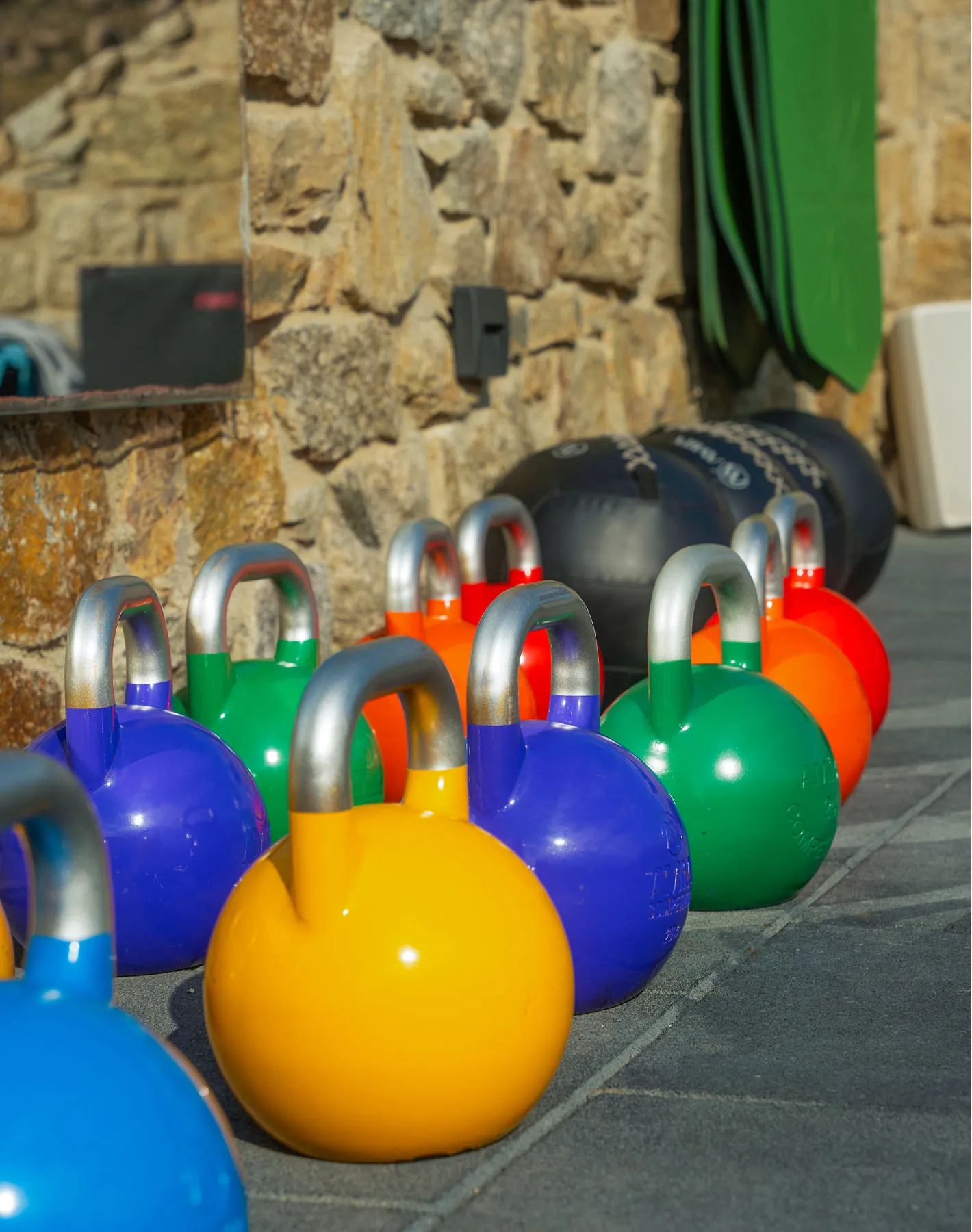 Colorful kettlebells at Cali Mykonos Terra Wellness Club’s outdoor gym